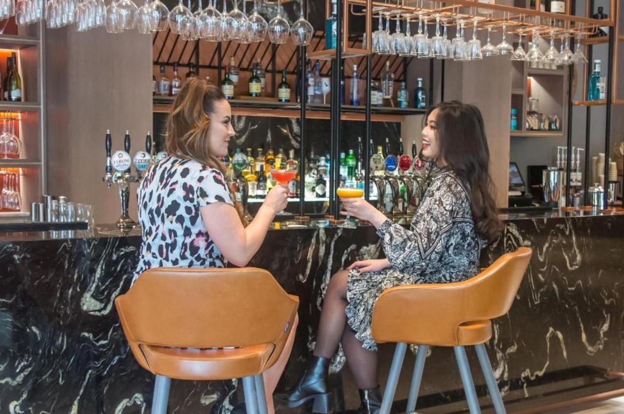 Clayton Hotel Manchester City Centre المظهر الخارجي الصورة Two women talking while having drinks at a bar